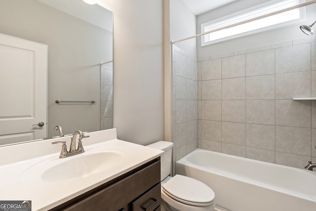 full bathroom with tiled shower / bath combo, toilet, and vanity