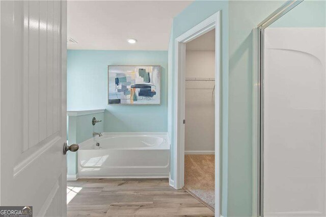 bathroom featuring a washtub and wood-type flooring