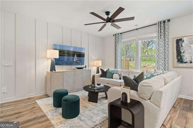 living room featuring ceiling fan and light hardwood / wood-style flooring