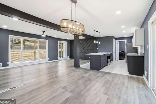 kitchen with pendant lighting, ceiling fan with notable chandelier, washer / clothes dryer, and light hardwood / wood-style flooring