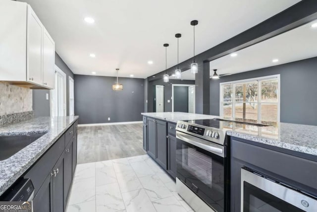 kitchen with white cabinetry, pendant lighting, light stone counters, and appliances with stainless steel finishes