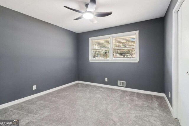 carpeted spare room with ceiling fan