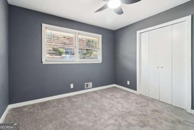 unfurnished bedroom with ceiling fan, a closet, and light colored carpet