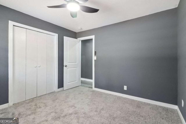 unfurnished bedroom with light carpet, a closet, and ceiling fan