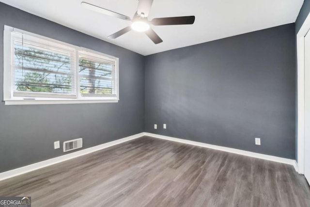 spare room featuring dark hardwood / wood-style flooring and ceiling fan