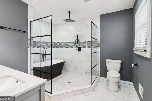 bathroom featuring tiled shower, vanity, and toilet