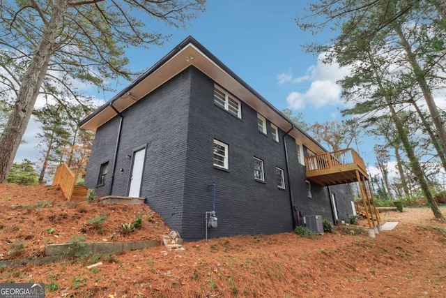 view of side of property featuring a balcony and central air condition unit