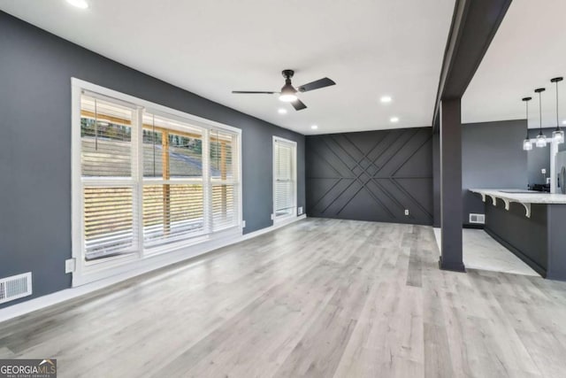 unfurnished living room with light hardwood / wood-style floors and ceiling fan