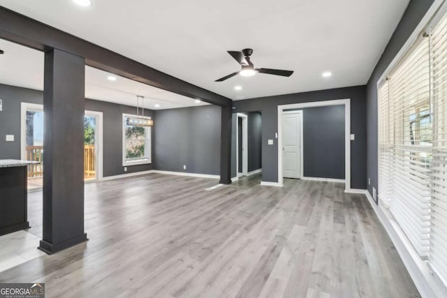 unfurnished living room with ceiling fan and light hardwood / wood-style flooring