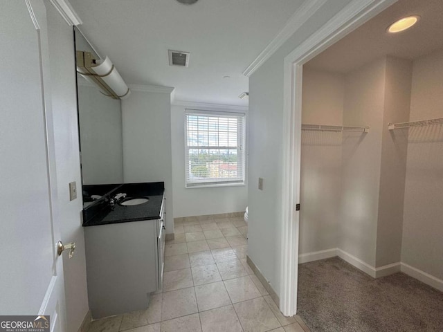 bathroom with tile patterned flooring, vanity, and crown molding