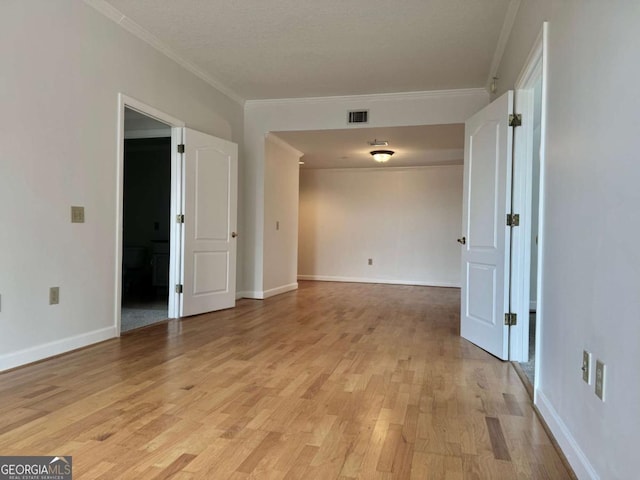 spare room featuring light hardwood / wood-style floors and ornamental molding