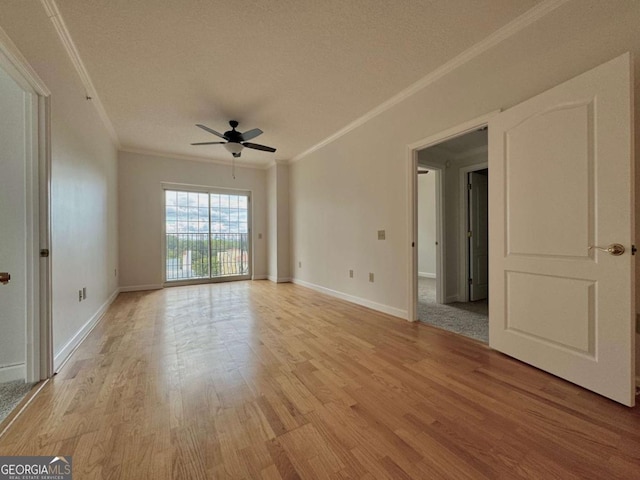 empty room with a textured ceiling, ceiling fan, light hardwood / wood-style floors, and crown molding