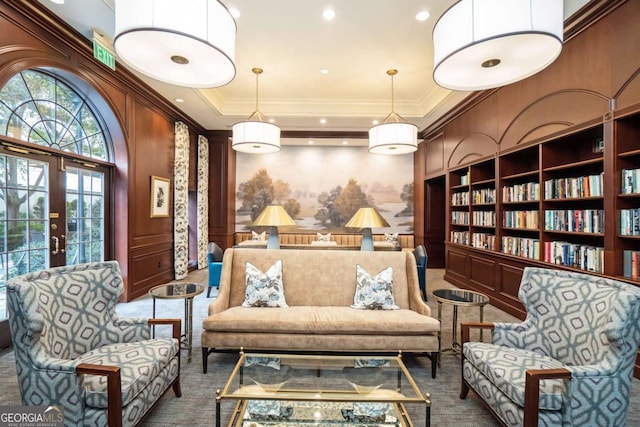 living area with crown molding, built in features, and french doors