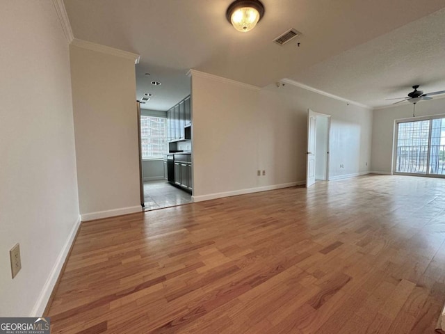 unfurnished living room featuring light hardwood / wood-style flooring, plenty of natural light, and crown molding