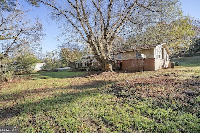 view of yard with a deck and central AC unit