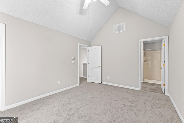 unfurnished bedroom featuring a textured ceiling, ceiling fan, lofted ceiling, and light carpet