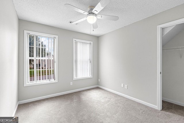 unfurnished bedroom with carpet, ceiling fan, a textured ceiling, and a closet