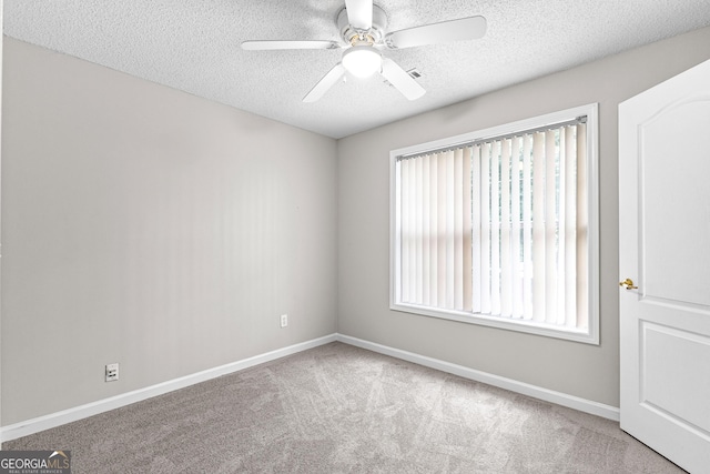 carpeted spare room featuring a textured ceiling and ceiling fan