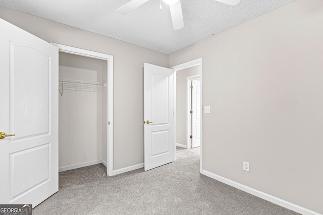 unfurnished bedroom with ceiling fan, light colored carpet, a textured ceiling, and a closet