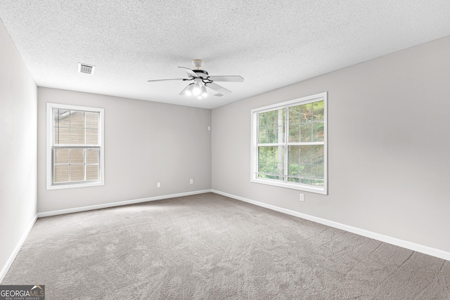 unfurnished room with carpet flooring, ceiling fan, and a textured ceiling