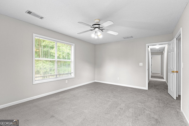 carpeted empty room featuring a textured ceiling and ceiling fan