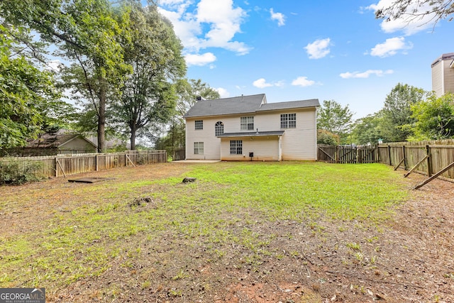 rear view of house featuring a patio area and a yard