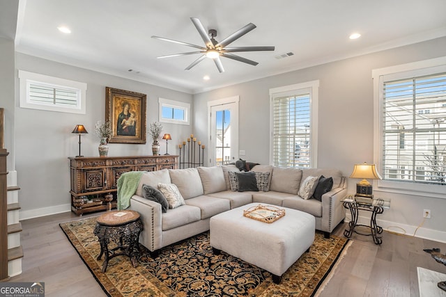 living room featuring crown molding, light hardwood / wood-style flooring, and ceiling fan