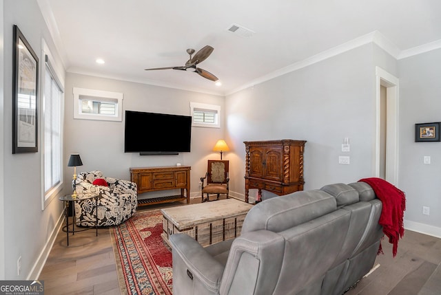 living room with hardwood / wood-style floors, ceiling fan, and crown molding