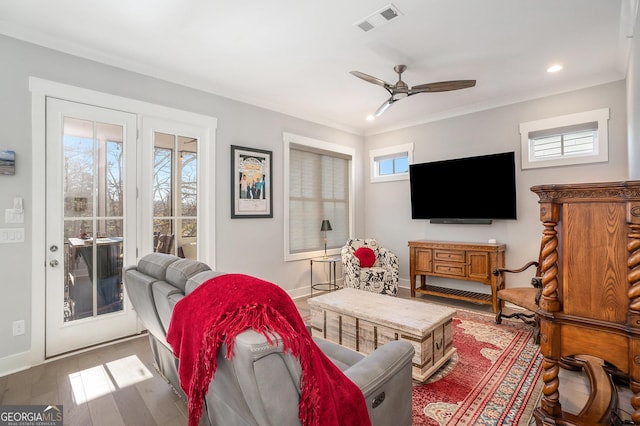 living room with hardwood / wood-style floors, ceiling fan, and crown molding