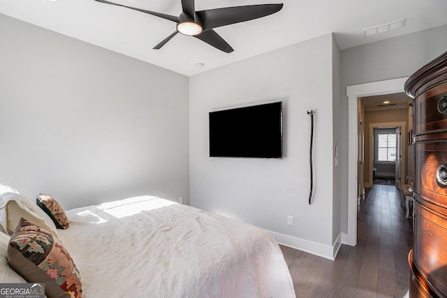 bedroom with dark hardwood / wood-style flooring and ceiling fan