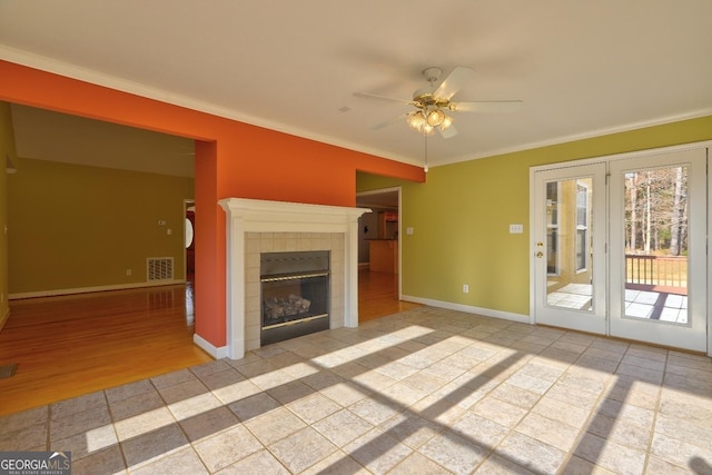 unfurnished living room with a fireplace, ceiling fan, light tile patterned floors, and crown molding