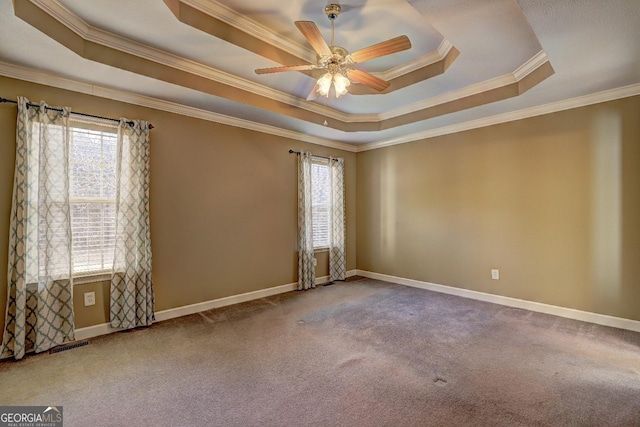 spare room with carpet, a tray ceiling, ceiling fan, and crown molding