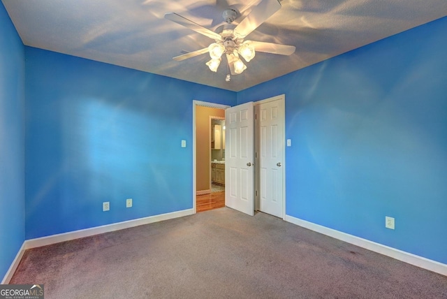 carpeted spare room with ceiling fan and a textured ceiling