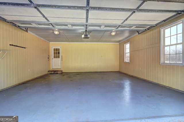 garage with a garage door opener and wood walls