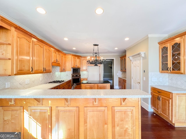 kitchen featuring crown molding, an inviting chandelier, decorative light fixtures, appliances with stainless steel finishes, and kitchen peninsula