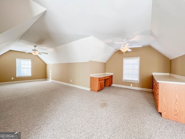 bonus room with lofted ceiling, light carpet, and ceiling fan