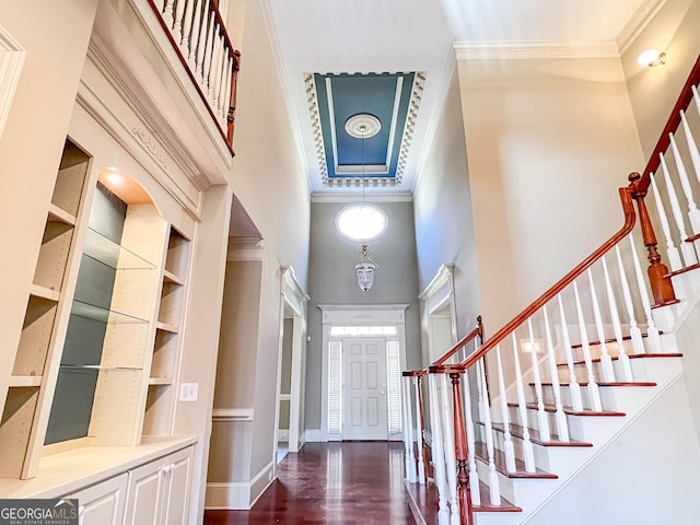 entrance foyer featuring a high ceiling, crown molding, and dark hardwood / wood-style flooring