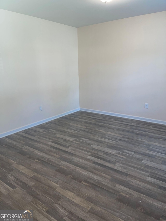 spare room with dark wood-type flooring