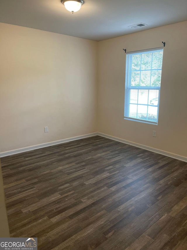 unfurnished room with dark hardwood / wood-style flooring