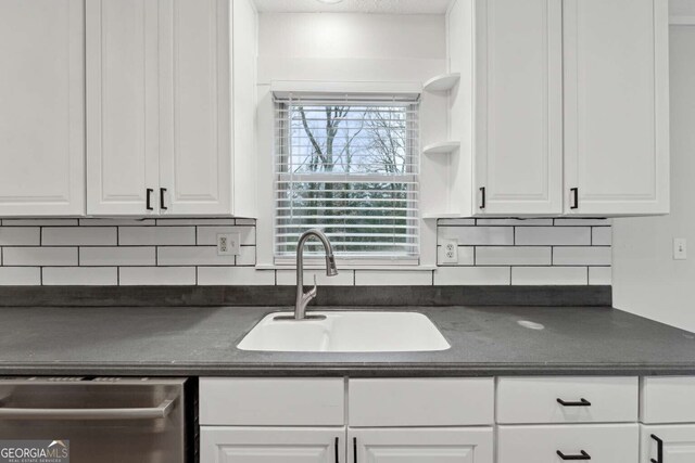 kitchen featuring tasteful backsplash, white cabinetry, dishwasher, and sink