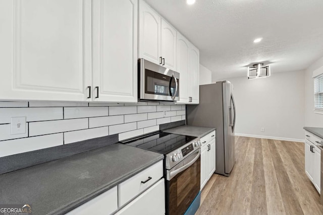 kitchen featuring white cabinets, a textured ceiling, appliances with stainless steel finishes, tasteful backsplash, and light hardwood / wood-style floors