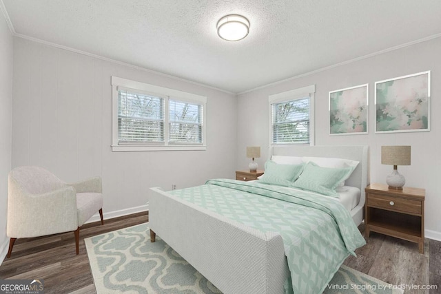 bedroom with a textured ceiling, hardwood / wood-style flooring, multiple windows, and ornamental molding