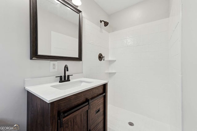 bathroom featuring vanity and tiled shower