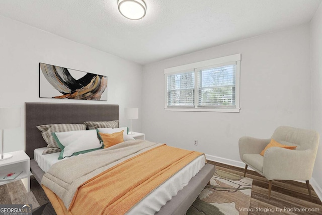 bedroom featuring a textured ceiling and dark hardwood / wood-style floors