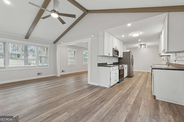 kitchen featuring lofted ceiling with beams, sink, appliances with stainless steel finishes, light hardwood / wood-style floors, and white cabinetry