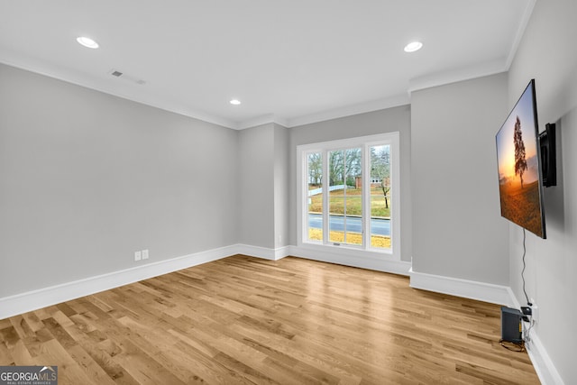 unfurnished room with light hardwood / wood-style floors and crown molding