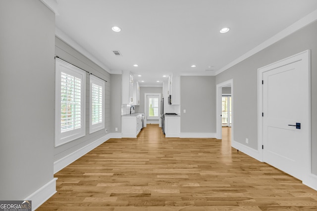 unfurnished living room with light hardwood / wood-style floors and ornamental molding