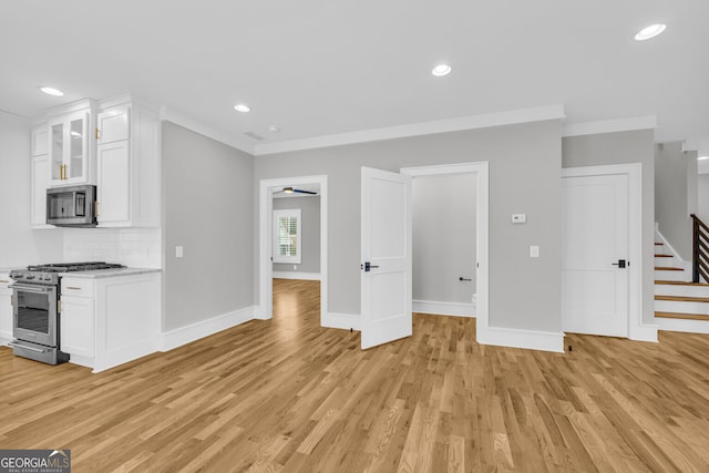 unfurnished living room with ceiling fan, light hardwood / wood-style flooring, and crown molding