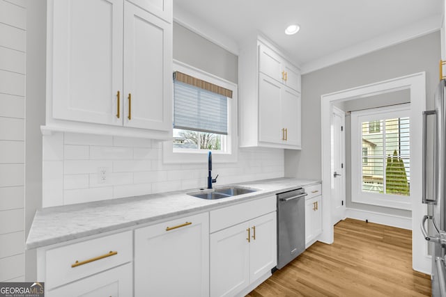 kitchen featuring light stone countertops, a wealth of natural light, sink, dishwasher, and white cabinetry