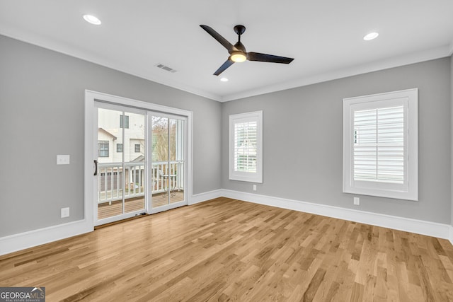 spare room featuring ceiling fan, a healthy amount of sunlight, crown molding, and light hardwood / wood-style flooring